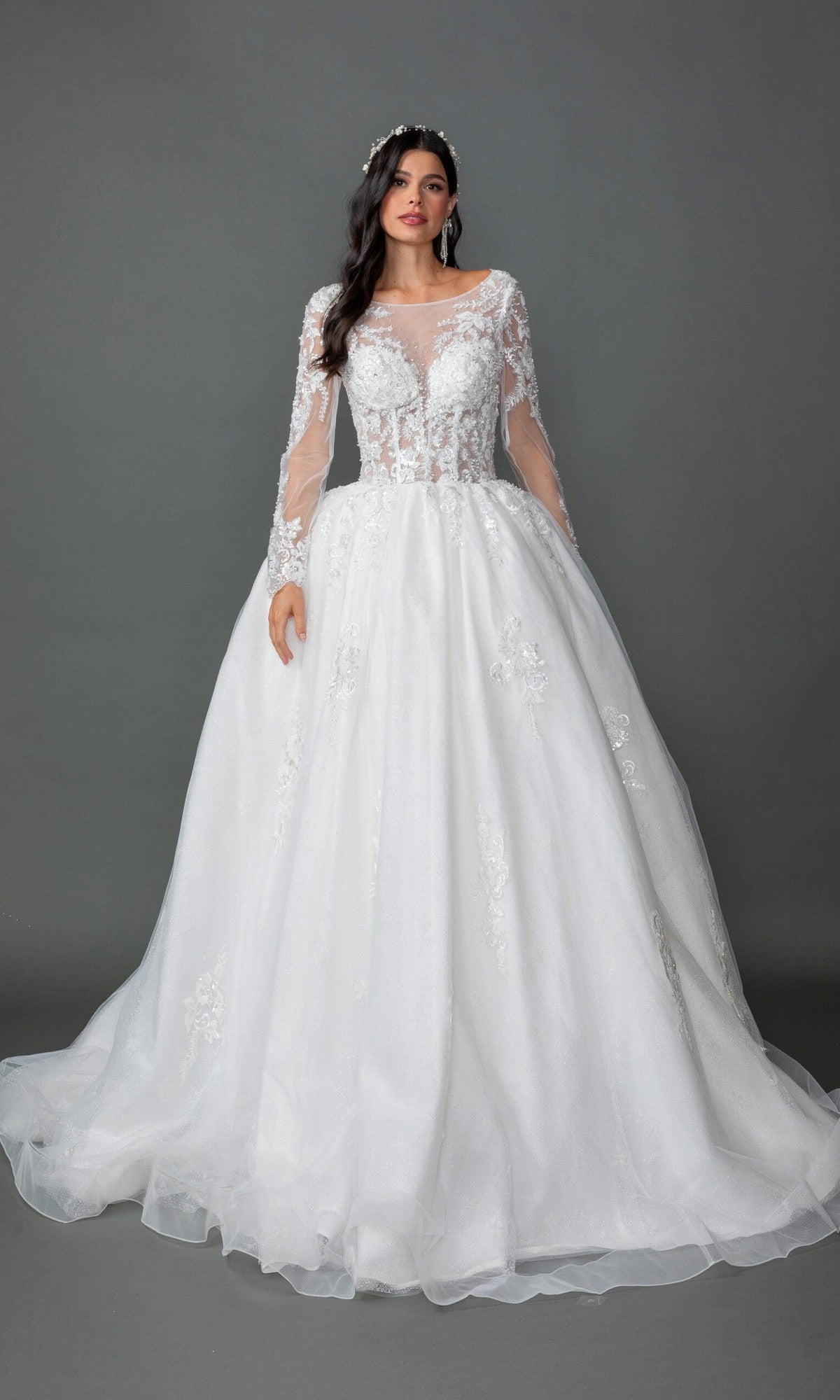A woman stands against a plain gray background wearing the Long Wedding Dress 0325 by Dancing Queen, an off-white gown featuring long sleeves, floral lace appliques, and an elegant A-line skirt.